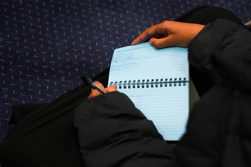 An open notebook held on a pupil's lap