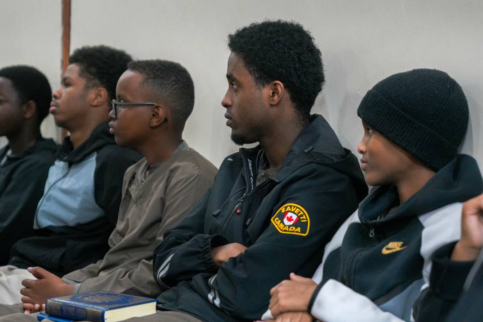 Boys sitting against the wall, listening