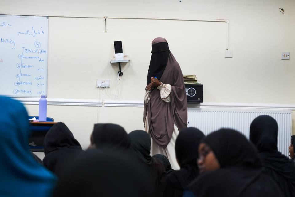 The teacher of the sisters' class standing at the front