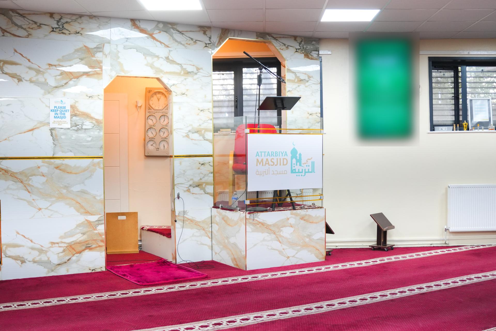 The mihrab, set in a marble wall, beside the minbar