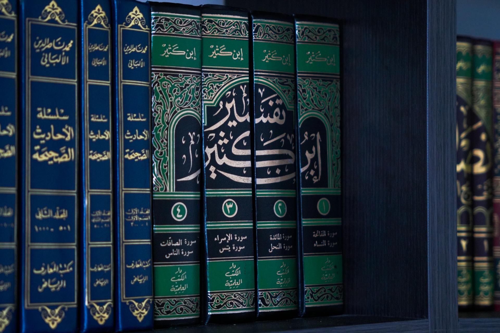 Green and gold volumes of Tafsir Ibn Kathir on a shelf